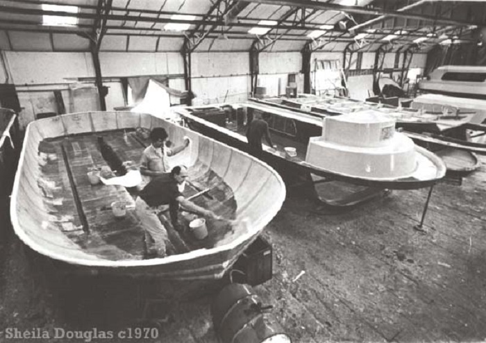 Applying one of the layers of fibreglass to a Caribbean cruiser c1970.